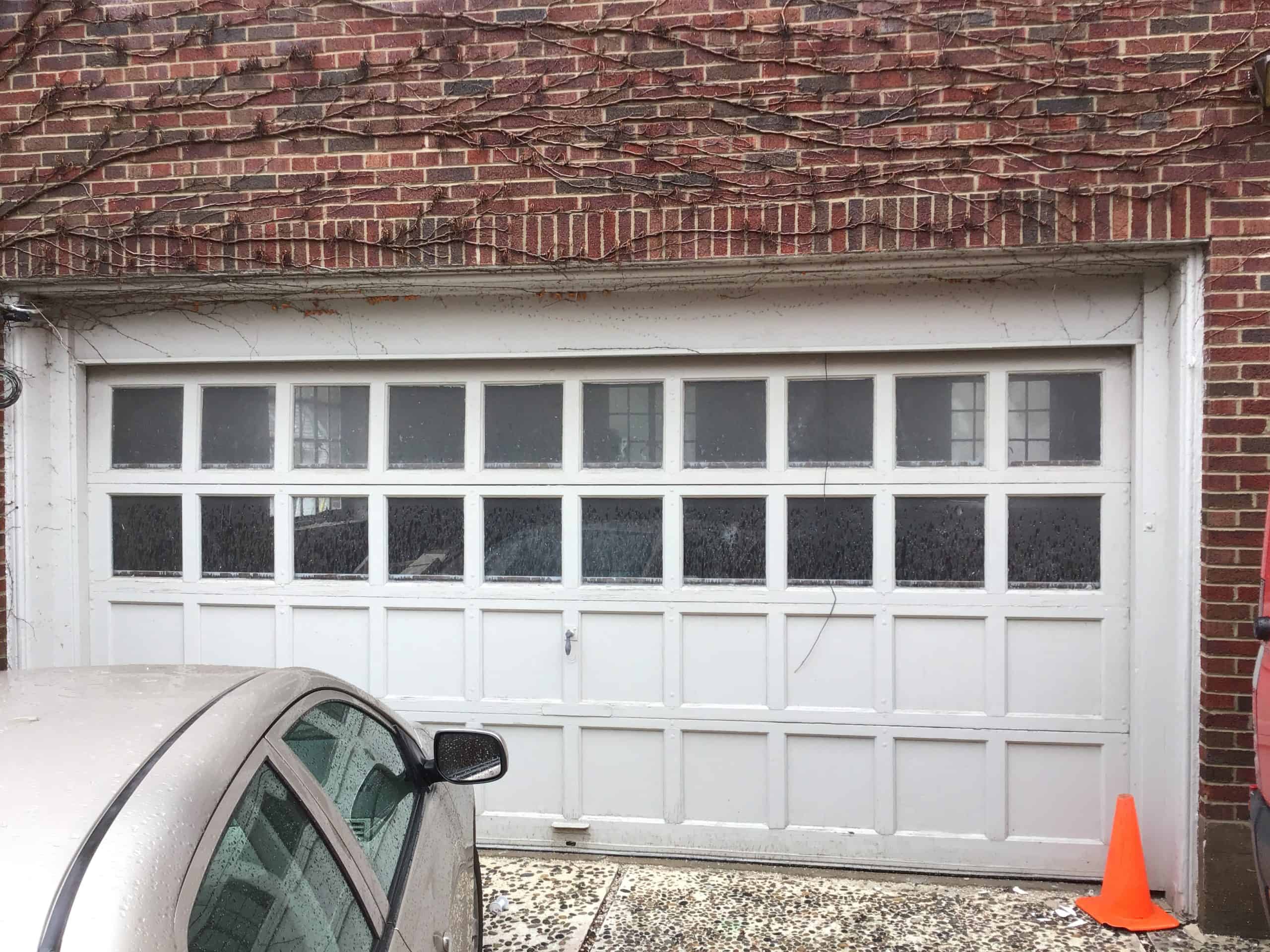 White garage door that is showing some wear.