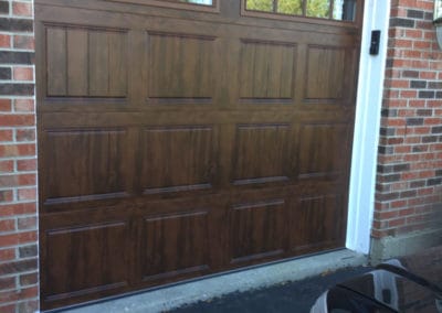 Clopay wooden double garage door. Wide Horizontal windows at top installation in Illinois