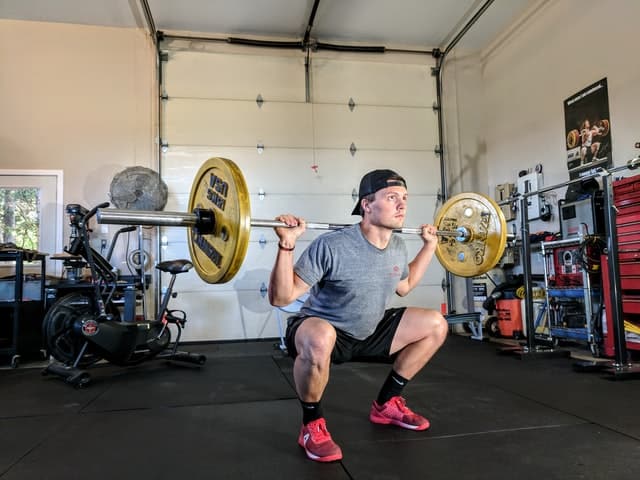 A man works out in his home gym in the garage