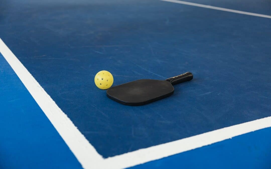 Pickleball paddle and ball on pickleball court